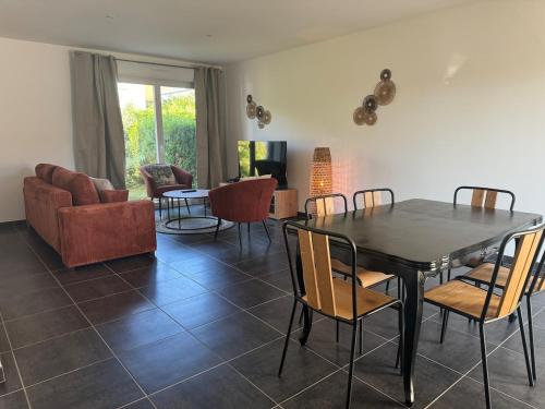 un salon avec une table et des chaises de salle à manger dans l'établissement Gîte l'Escale, à Jeuxey