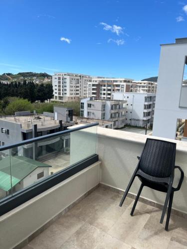 a chair on a balcony with a view of buildings at Skyline View Apartment in Ulcinj