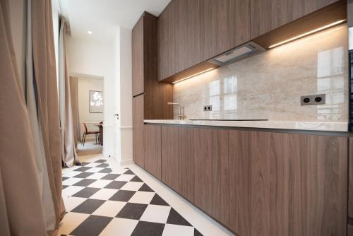 - une cuisine avec un comptoir et un sol en damier dans l'établissement Appartement de luxe d'une chambre près du Louvre II, à Paris