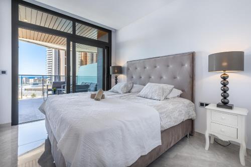 a bedroom with a large bed and a large window at Sunset Waves IV by Terreta Rentals in Benidorm