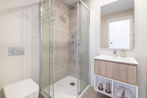 a bathroom with a shower and a toilet and a sink at Sunset Waves IV by Terreta Rentals in Benidorm