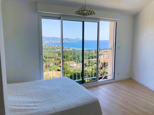 une chambre avec un lit et une grande fenêtre dans l'établissement Villa avec grande terrasse vue mer, à Sainte-Maxime