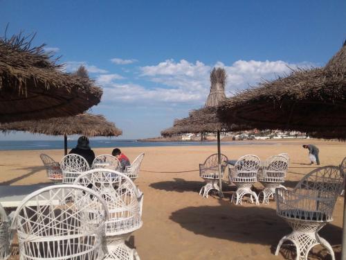 a group of chairs and umbrellas on a beach at Résidence Bouznika 2 in Bouznika