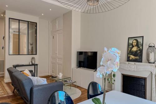un salon avec un canapé, une table et une télévision dans l'établissement #HW Le Mazet Hyper-centre Haussmanian apartment, à Grenoble