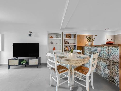 une salle à manger avec une table et des chaises et une télévision dans l'établissement Appartement spacieux & vue imprenable, à Saint-Laurent-du-Var