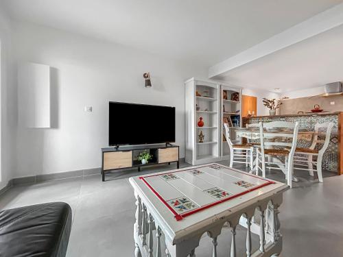 un salon avec une télévision et une table dans l'établissement Appartement spacieux & vue imprenable, à Saint-Laurent-du-Var