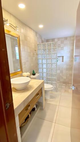 a bathroom with two sinks and a toilet and a mirror at Stunning Ajijic Lake Chapala 2 Bdrm Retreat -Bikes - Gym - Pickleball Court in Ajijic