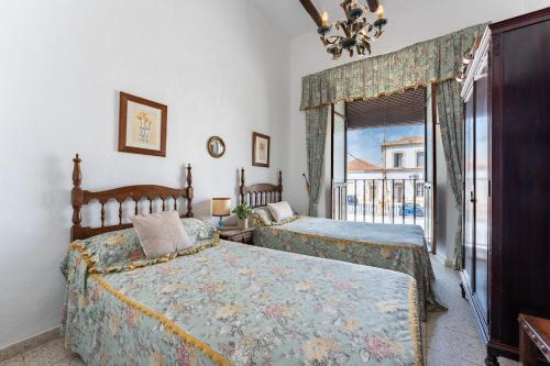 une chambre avec deux lits et une fenêtre dans l'établissement MalagaSuite Bobadilla Casa Rural, à Antequera