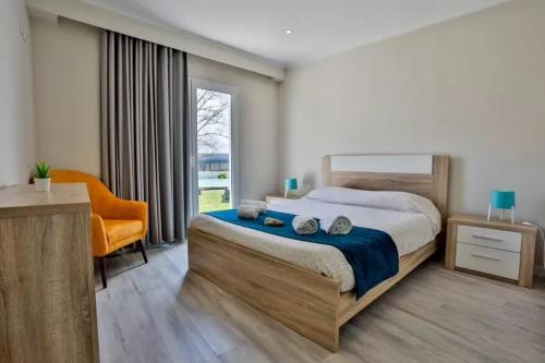 a bedroom with a bed and a chair and a window at Charming House with Pool in Atalaia in Lourinhã