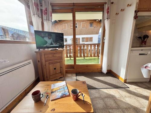a living room with a television and a coffee table at Appartement au pied des pistes avec terrasse, parking privé, casier à skis, proche commerces - FR-1-595-75 in Crest-Voland