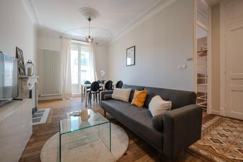 un salon avec un canapé et une table en verre dans l'établissement #HW Le Mazet Hyper-centre Haussmanian apartment, à Grenoble