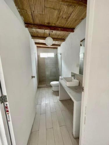 a bathroom with a toilet and a sink and a mirror at Bungalows en playa Wakama in San Vicente de Cañete