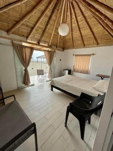 a bedroom with a bed and a bench in a room at Bungalows en playa Wakama in San Vicente de Cañete