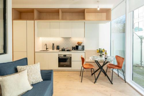 a living room with a blue couch and a table at Chiswick Parkside Apartments by Sleepy Lodge London in Kew Bridge