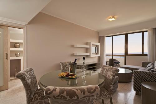 a living room with a table and chairs at Atlantica Oasis Hotel in Limassol