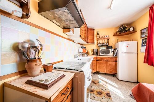 une cuisine avec une cuisinière et un réfrigérateur dans l'établissement Les Hortensias, à Reignier-Ésery