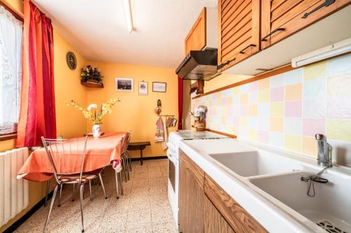 a small kitchen with a table and a sink at Les Hortensias in Reignier