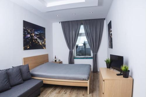 a bedroom with a bed and a couch at Magic Place parking, Air Conditioning, Self Check In in Oświęcim