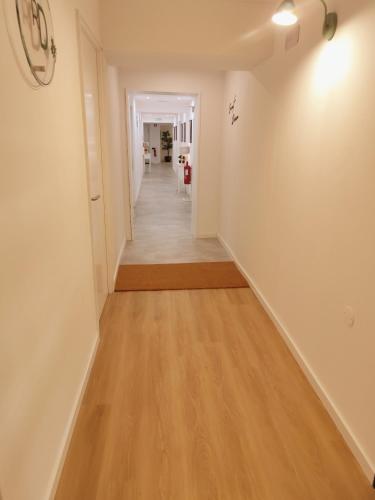 a hallway with white walls and a wooden floor at Residencial Douro in Peso da Régua