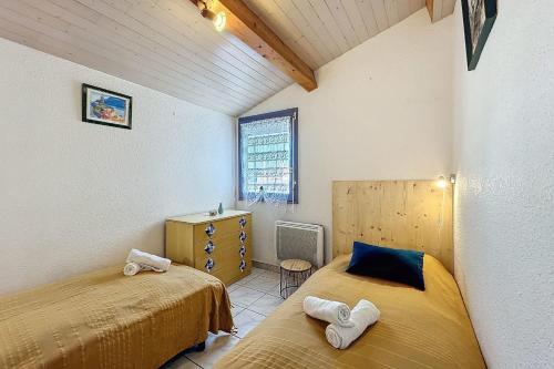 une chambre avec deux lits et une commode et une fenêtre dans l'établissement Magnificent apartment - near the beach, à Narbonne