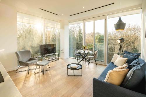 a living room with a couch and chairs and a tv at Chiswick Parkside Apartments by Sleepy Lodge London in Kew Bridge