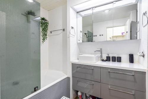 une salle de bain avec un lavabo, une douche et un miroir dans l'établissement GuestReady - Cosy studio near Arc de Triomphe, à Paris