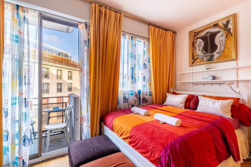 une chambre avec un lit et une grande fenêtre dans l'établissement GuestReady - Cosy studio near Arc de Triomphe, à Paris