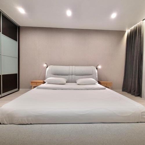 una camera da letto con un grande letto bianco con due cuscini di ApartPoltava Premium Relax двокімнатні апартаменти з ДЖАКУЗІ a Poltava
