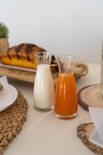 a table with two glasses of milk and a tray of bread at Hotel Alexandros in Ammoudia