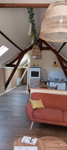 un salon avec un canapé rouge et une cuisine dans l'établissement Gite la pause picarde, à Franleu