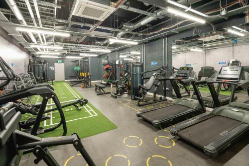 a gym with several treadmills and cardio machines at Chiswick Parkside Apartments by Sleepy Lodge London in Kew Bridge