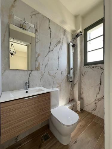 a bathroom with a toilet and a sink and a mirror at Kores Aegina in Agia Marina Aegina