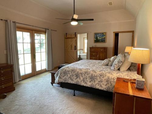 a bedroom with a bed and a ceiling fan at Rose Hill Farms- Relax at Your 12 Acre Farmhouse Retreat ! in Brenham