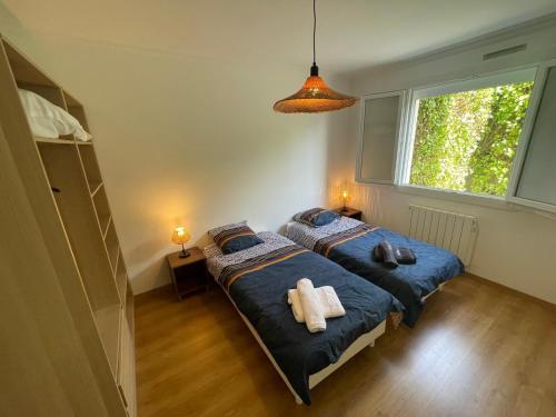 a bedroom with two beds and a window at Maison au calme rénovée plain-pied, hyper centre ville Perros in Perros-Guirec