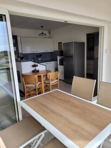 une cuisine et une salle à manger avec une table et des chaises dans l'établissement Plage à pied, au Barcarès