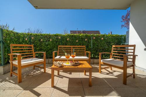 trois chaises et une table avec des boissons sur une terrasse dans l'établissement Le Blue Wave - Unique Proche Gare, à Brumath
