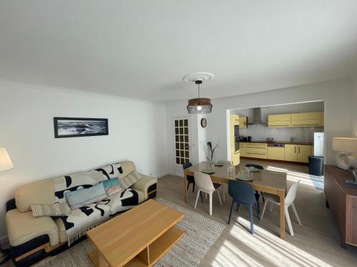 un salon avec un canapé et une table dans l'établissement Maison au calme rénovée plain-pied, hyper centre ville Perros, à Perros-Guirec