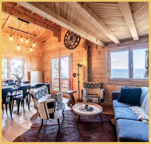 - un salon avec un canapé bleu, des chaises et une table dans l'établissement Chalet I Sous le Bois, à Bonne