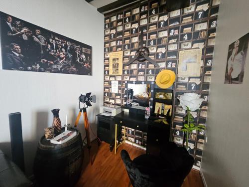 een kamer met een muur met foto's erop bij "Studio Cinéma" -Coeur de ville- Spacieux, calme et connecté-alexa, wifi, free, netflix, disney, prime video, jeux vidéo et de société in Auxerre