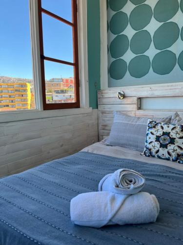 a bedroom with a bed with a rolled up towel on it at BbCasita Yellow in Valparaíso