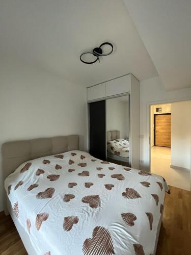 una camera da letto con un grande letto bianco con un ventilatore a soffitto di Apartment a Skopje