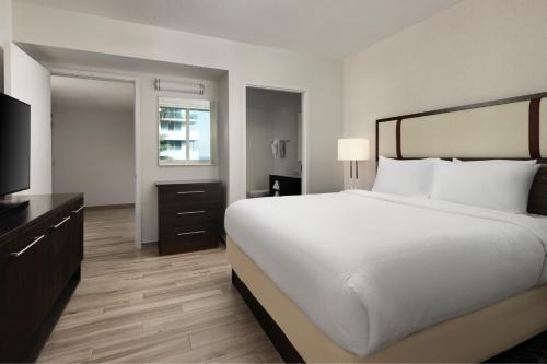 a bedroom with a large white bed and a television at Residence Inn by Marriott Miami Beach Surfside in Miami Beach