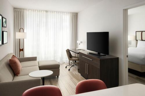 a living room with a couch and a flat screen tv at Residence Inn by Marriott Miami Beach Surfside in Miami Beach