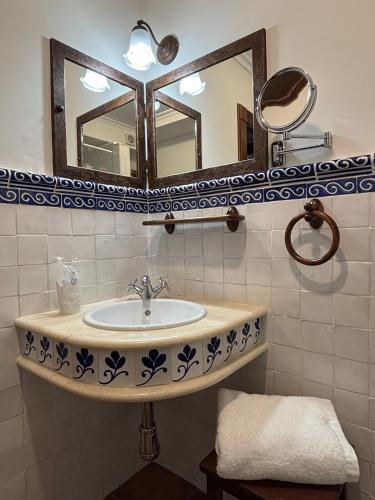 a bathroom with a sink and a mirror at As Tapias Apartamentos in Tapia de Casariego