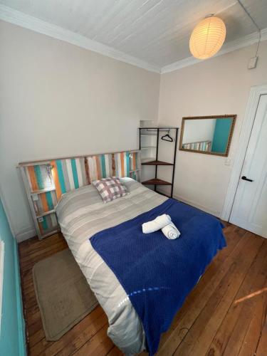 a bedroom with a bed with two towels on it at BbCasita Yellow in Valparaíso