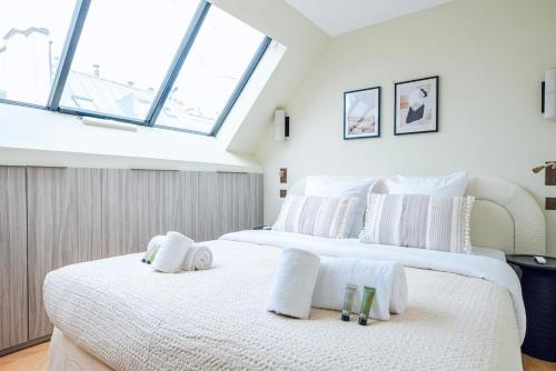 deux lits dans une chambre avec deux fenêtres dans l'établissement Stylish Triplex with Amazing Terrace near Louvre, à Paris