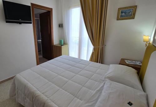 a bedroom with a white bed and a window at Hotel Il Nido Sorrento in Sorrento