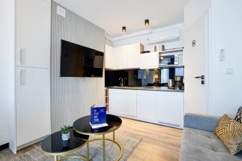 a living room with a couch and a table with a box on it at ApartPark by Baltic Home in Świnoujście