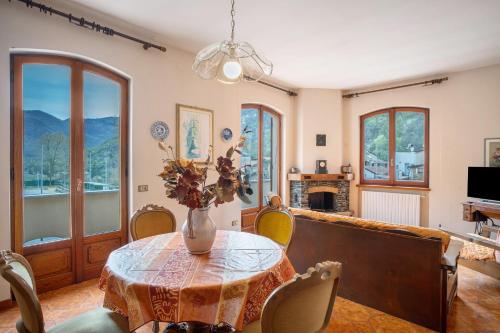 a dining room with a table with a vase of flowers at Casa Lilli in Pieve di Teco