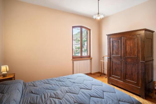 a bedroom with a bed and a wooden cabinet at Casa Lilli in Pieve di Teco